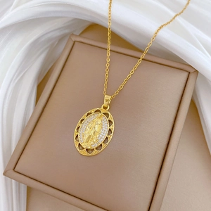 Detailed close-up of gold titanium steel oval pendant with portrait and crystals