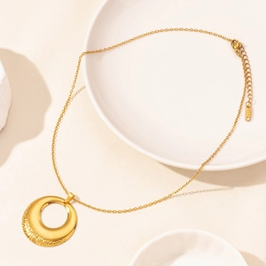 Detailed close-up of 18k gold plated round pendant necklace with hammered texture finish