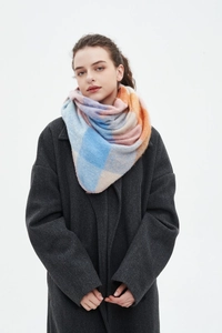 Detail view of soft plaid knit scarf featuring blue pink and orange color blocks