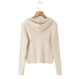 Detail view of cream cable knit zip-up hoodie featuring textured weave and hood structure