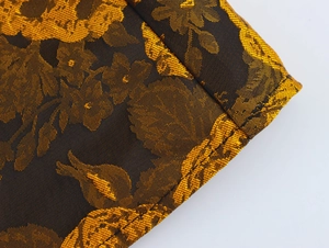 Close-up of vintage black and gold floral jacquard fabric with detailed brocade texture