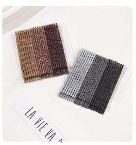 Detail view of glitter bobby pins in champagne and silver on a card holder