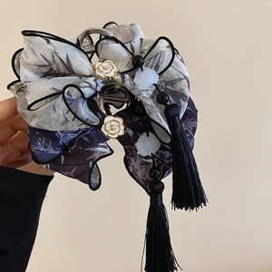 Détail d'une pince à cheveux avec nœud de style chinois et glands en soie fine