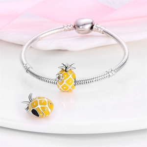Detailed shot of silver snake chain bracelet with two yellow enamel pineapple charms