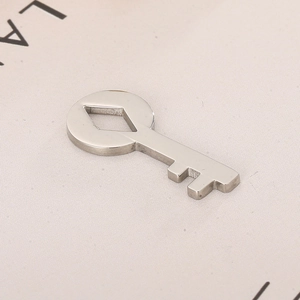 Close-up of a silver stainless steel hollow heart-shaped key pendant on textured fabric