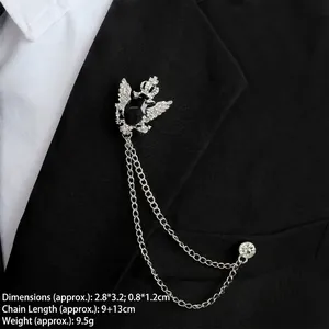 Detail of silver crown eagle brooch with black gemstone and double hanging chains