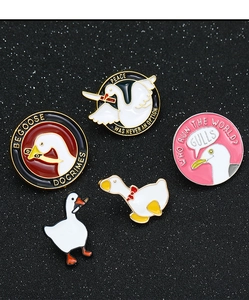 Detailed close-up of funny enamel duck pins with 'Be Goose Do Crimes' text on dark background