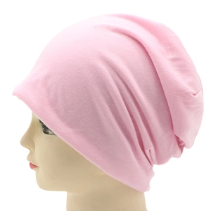 Close-up of pink knit slouchy beanie cap on model with soft cotton texture details