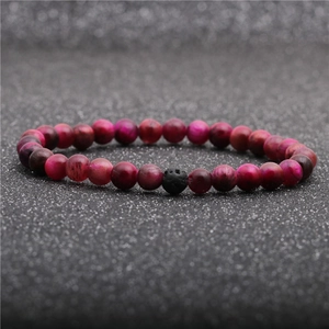Close-up of rose red tiger eye beads and black lava stone on a stretch bracelet
