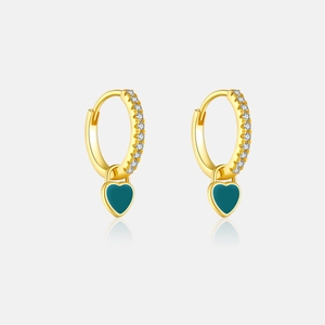 Détail de boucles d'oreilles cœur dorées avec zircons blancs et émail vert foncé