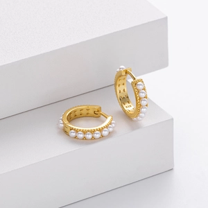 Detail of 925 sterling silver stamp on gold-plated hoop earrings with small pearls
