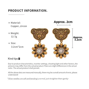 Detail view of retro copper bear and daisy drop earrings with zircon inlays and dimensions