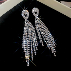 Close-up of sparkling rhinestone tassel earrings with a brilliant metallic silver finish