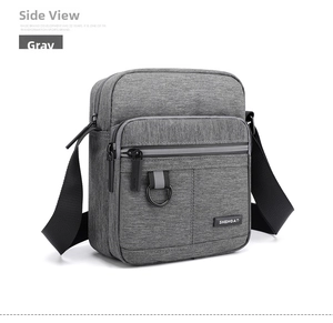 Detail view of water-resistant gray oxford fabric and metal ring on men's crossbody bag