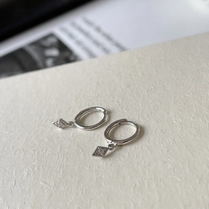 Macro shot of S925 sterling silver geometric rhombus earrings with sparkling crystals