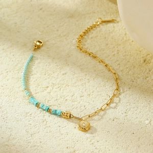 Gold-plated handmade beaded bracelet with sky blue square stones and vintage charms