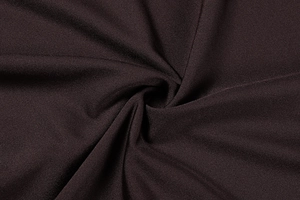 Macro view of dark chocolate knit fabric showing silky texture and elegant draping