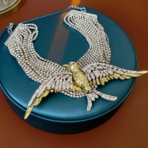 Macro detail of bird-shaped pendant and multi-layer rhinestone chain on jewelry box
