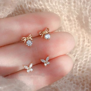 Macro view of 925 sterling silver bow knot stud earrings with zircon on fingers
