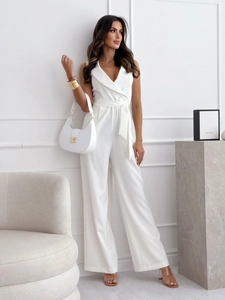 Detail of white sleeveless jumpsuit featuring deep V-neckline and high-waisted belt design