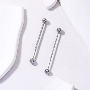 Detail of silver stainless steel industrial barbell featuring sparkling zircon stones