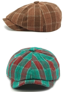Detailed view of vintage plaid newsboy caps in brown and green-red woolen patterns