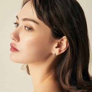 Minimalist silver leaf hoop earrings for women shown on a model in a close-up profile view