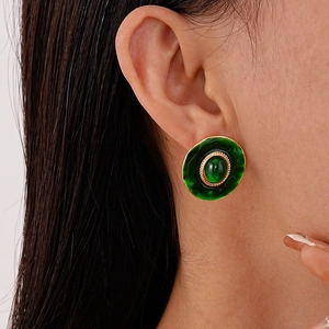 Vue détaillée de la boucle d'oreille rétro en résine verte avec bordure dorée
