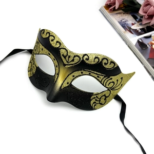 Detail of a Venetian black and gold lace masquerade mask with glittered floral patterns