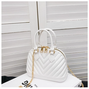 Detail of white shell-shaped jelly bag with V-pattern texture and gold chain strap