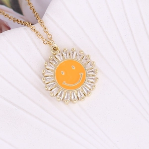 Gold sunflower necklace with orange enamel smiley face and zircon inlay on white shell