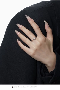 Detail of S925 silver ring with white agate gemstone worn on finger in high-fashion style