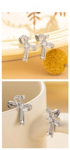 Detailed view of silver bow-knot stud earrings featuring a star motif and pavé cubic zirconia