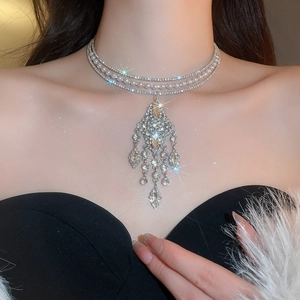 Macro detail of multi-layer rhinestone fringe pearl choker necklace on a female model