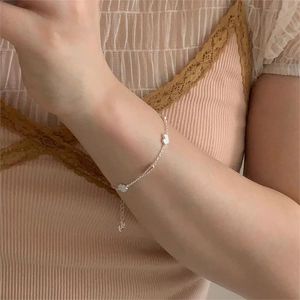 Close-up of S925 sterling silver chain bracelet with white flower and swan charms