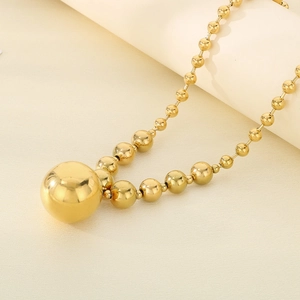 Macro shot of gold hollow bead pendant and spherical chain with metallic luster