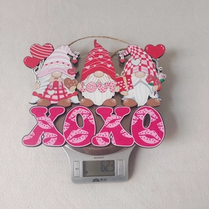 Détail d'un gnome suspendu en bois rose de la Saint-Valentin sur une balance
