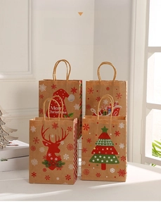 Close-up of four Christmas kraft paper gift bags with Santa, reindeer and tree patterns