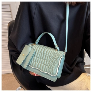 Detail of mint green crocodile embossed mini bag with wave edge and matching pouch