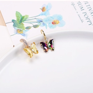 Close-up of asymmetric butterfly earrings with gradient crystals and micro-inlaid rhinestones
