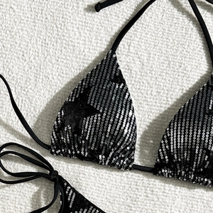 Macro detail of black sequined bikini top with halter tie and shiny striped texture