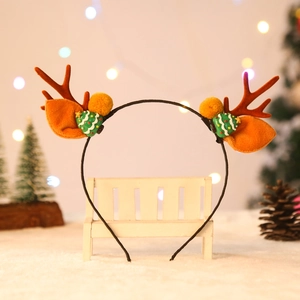 Dettaglio del cerchietto con corna di renna in peluche e decorazioni natalizie festive