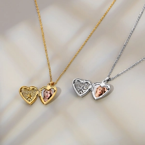 Detail of heart-shaped locket necklaces in gold and silver with intricate hollow design