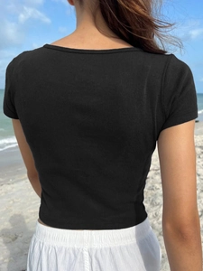 Back view of black ribbed knit T-shirt with slim fit on beach background