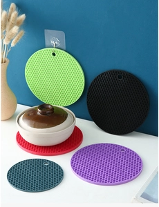 Close-up of circular silicone honeycomb coasters in five colors showing heat resistance