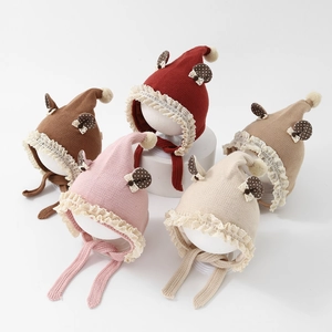 Detailed display of five colors of knit baby bonnets with lace trim and pom-poms