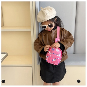 Toddler girl wearing a pink unicorn chest bag with stylish brown jacket and beret