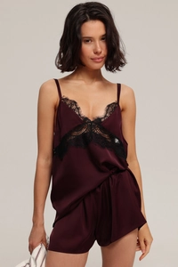 Detail showing the burgundy satin fabric and intricate black lace trim of the pajama set