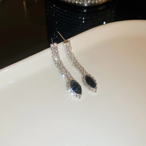 Macro shot of silver tassel earrings with sparkling rhinestones and black marquise gems