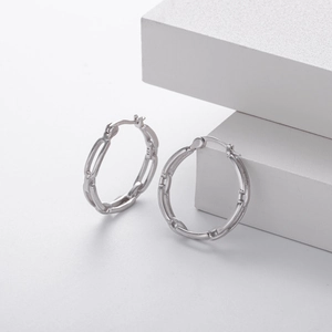 Close-up of S925 sterling silver hoop earrings with hollow bamboo link design on stone